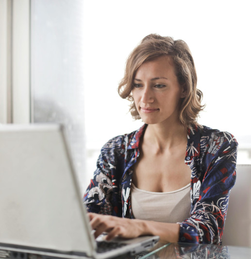 A woman is working at a laptop. 